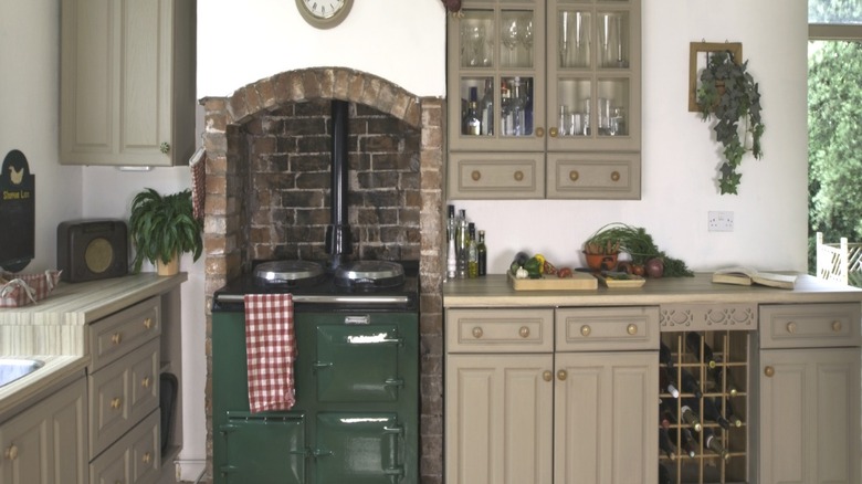 A traditional white and beige kitchen with green Aga stove