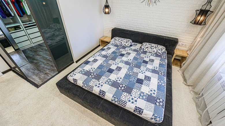 blue patchwork quilt on modern bed