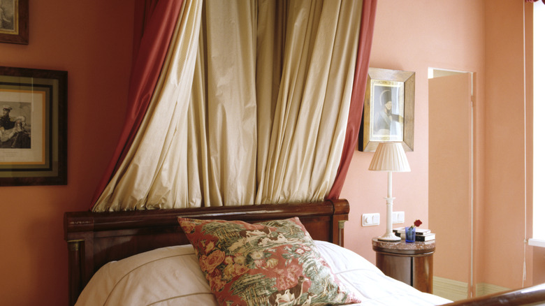 Draped fabric behind vintage bed.