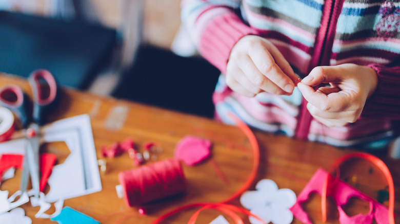 woman's hands working on crafts with fabrics and twine