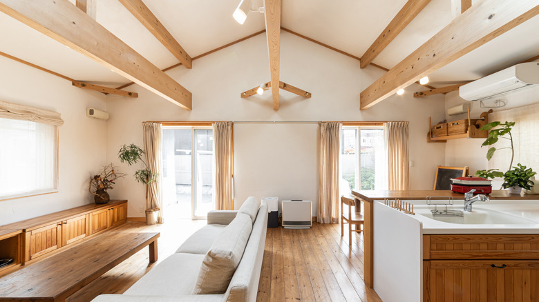 Living room space with rustic ceiling beams and stone fireplace