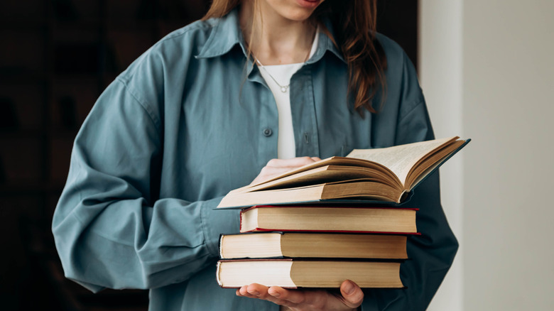 woman holding stack of books