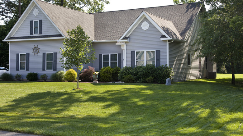 House with lush green grass in front yard.
