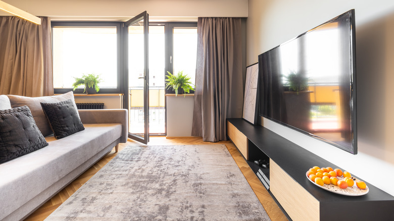 Large area rug in living room with hardwood floors