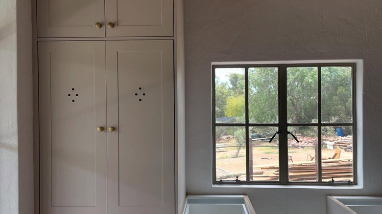 A newly renovated kitchen with cabinet vent holes in a tall cabinet