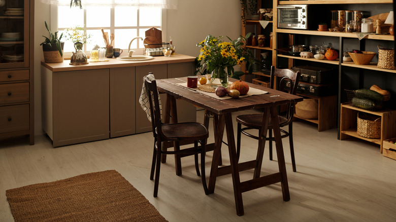A cottagecore kitchen with open shelves and cabinets under the sink