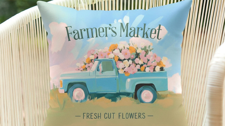 An blue, pink, and brown outdoor throw pillow on an outdoor chair