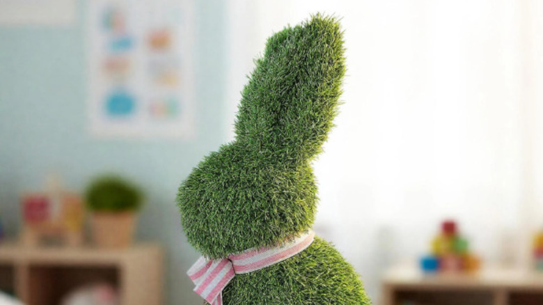 Faux grass bunny with pink bow sitting on table