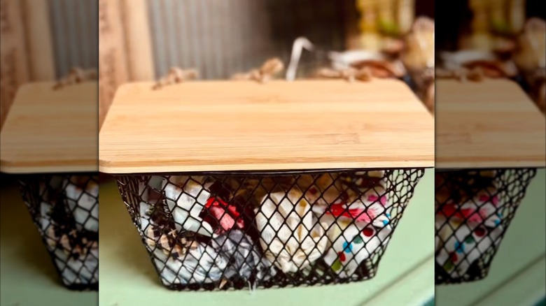 Storage basket made from a wire basket with a cutting board lid
