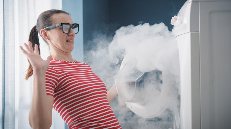 smoking dryer and shocked woman