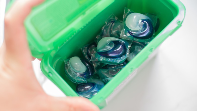 person holding detergent pod container