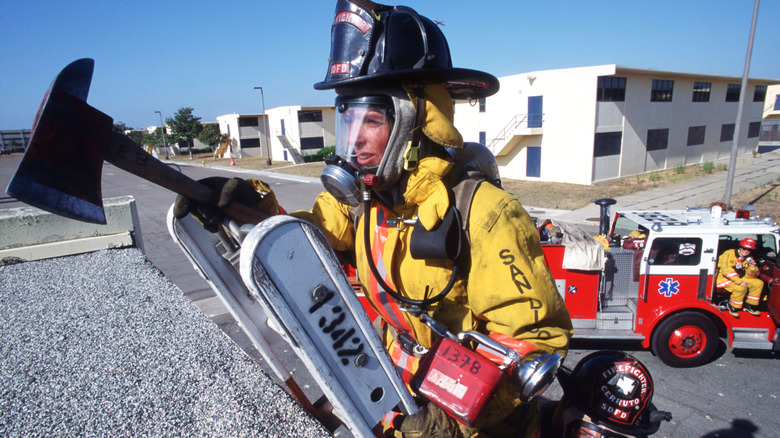 Firewoman carrying axe and ladder