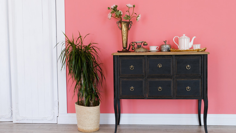 Hot pink wall behind vintage-style drawer in black