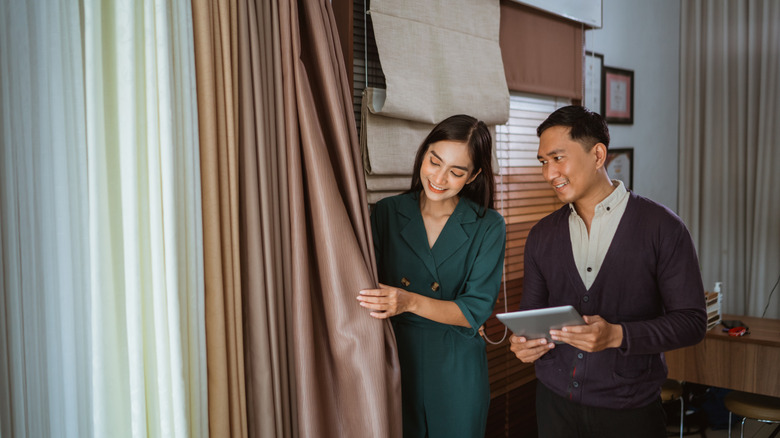 Two people shop for curtains in a store