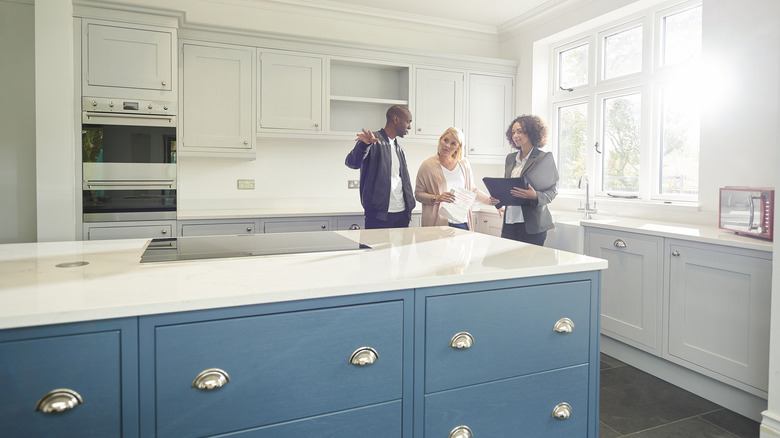 Realtor shows potential buyers a modern kitchen