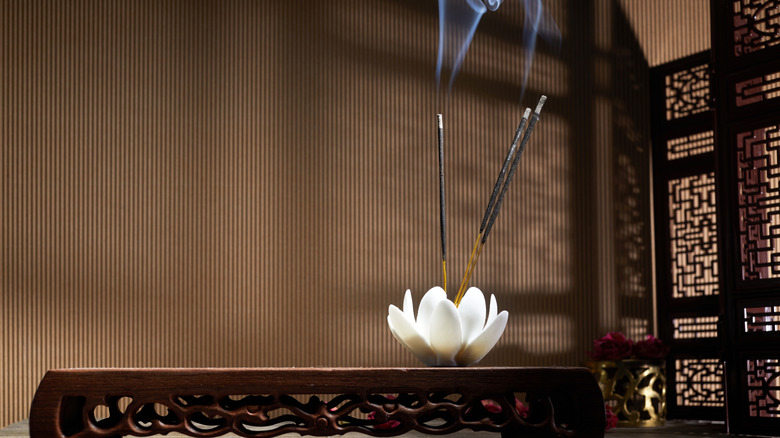 Incense sticks burning in a flower shaped incense holder