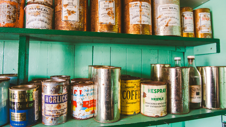 Vintage coffee tins on a green shelf