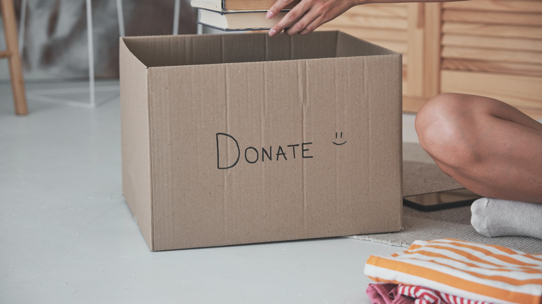 Cardboard donation box on floor with "Donate" written on it