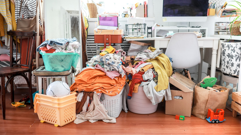 Messy home office space with full laundry baskets and toys