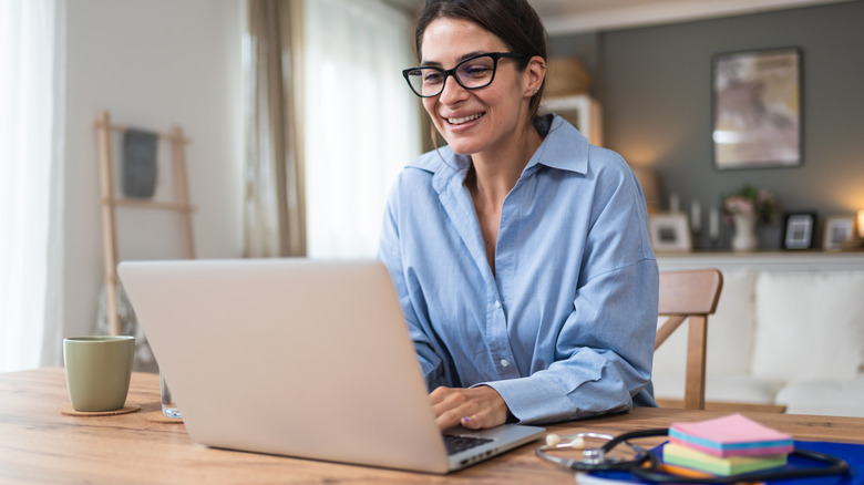 A woman smiling at her computer.