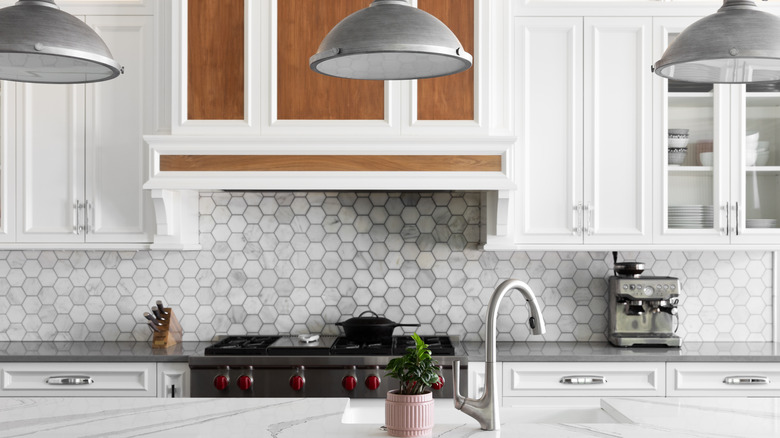 Kitchen with sheet hexagon tile backsplash lining.