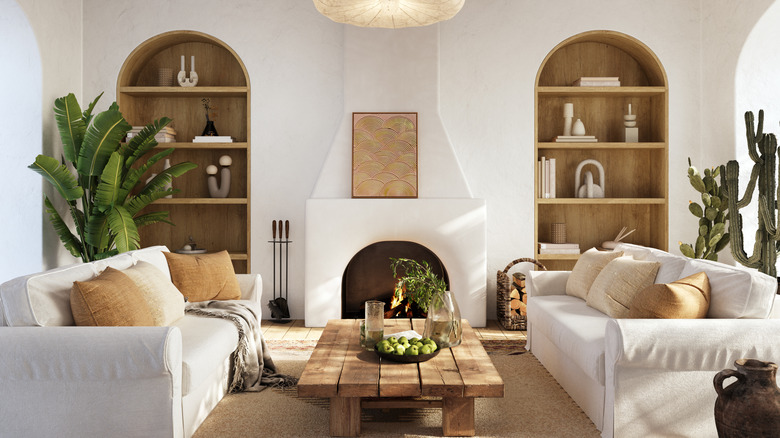 Living room with symmetrical sofas facing each other with a coffee table in the middle, fireplace between two arched alcoves.