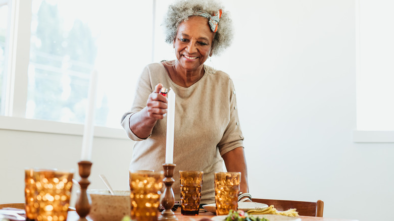 Woman lighting tapered candle