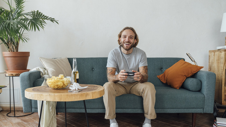 A man playing video games in a modern living room.