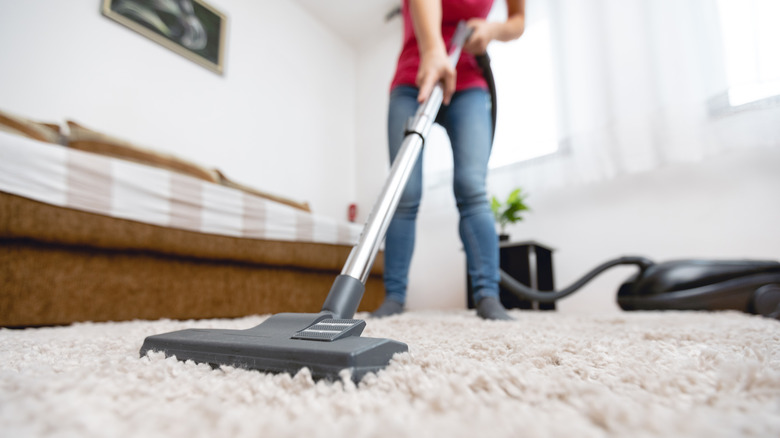 Woman vacuuming living room carpet