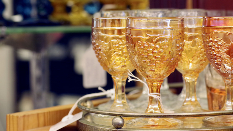 Orange depression era glass chalices on tray at antique store