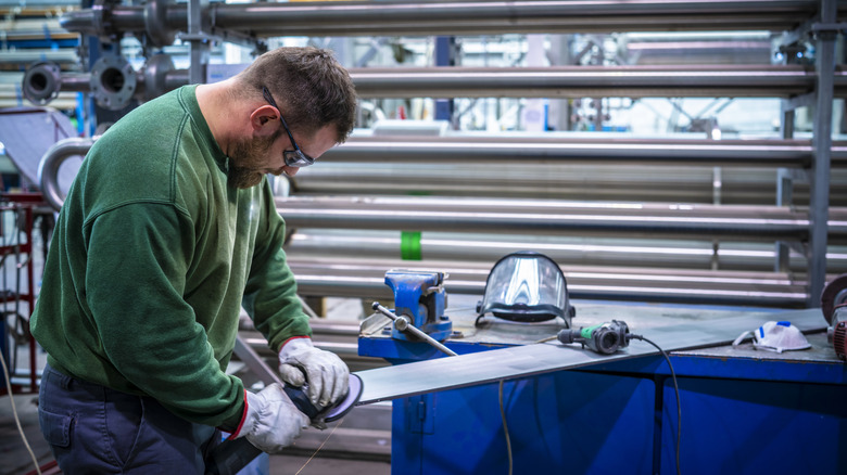man polishing stainless steel plate to a mirror finish