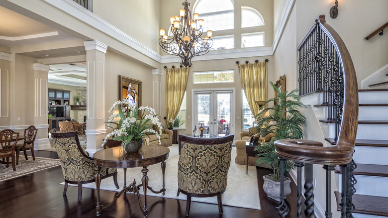 Large entryway in a house with traditional interior style featuring chairs and a chandelier