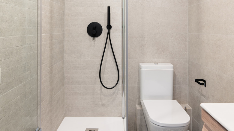 A small bathroom space with the shower and toilet side by side