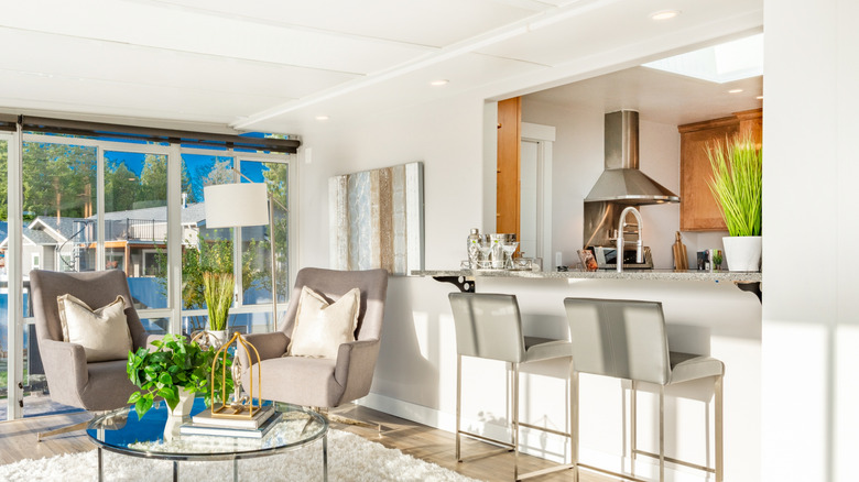 A clean, bright living room with a pass-though window into the kitchen.
