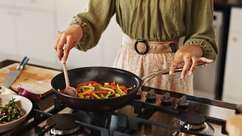 A woman cooking on a gas stove