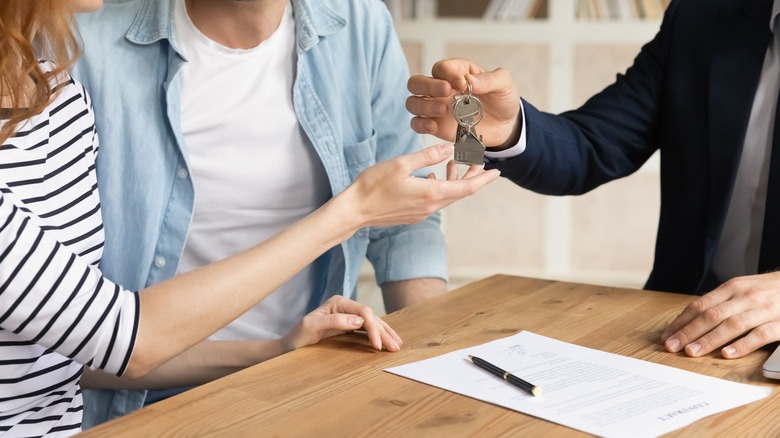 Person handing off home keys