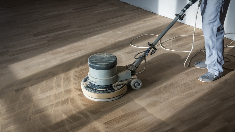 person sanding hardwood floors