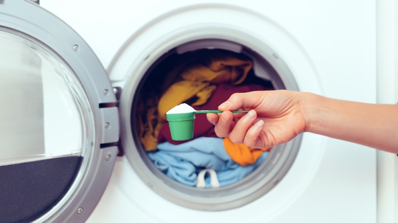 hand holding powder detergent scoop