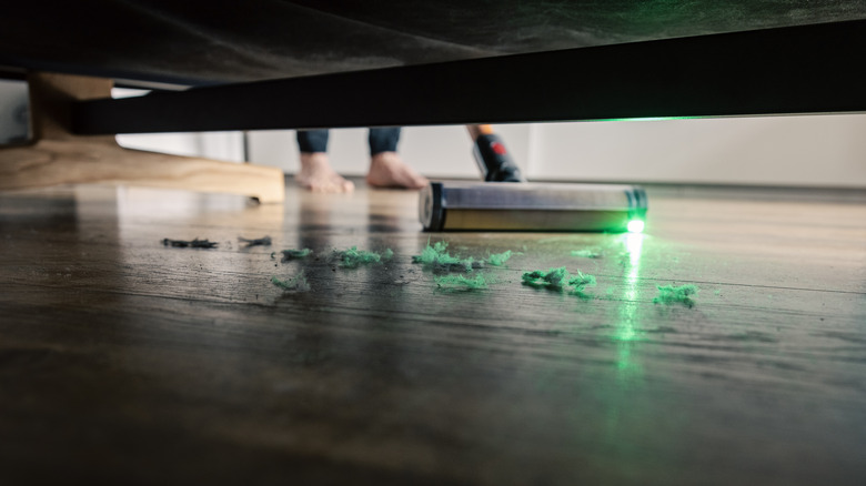 Dust under a bed with a vacuum cleaner hoovering it up