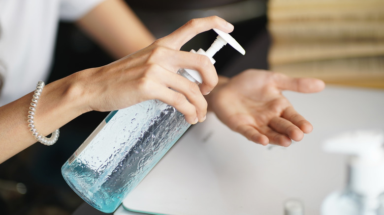 Women washing hands with alcohol gel