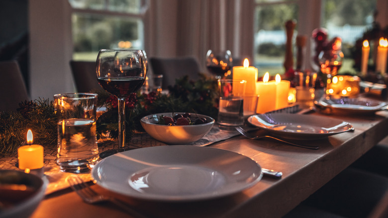Close up of festive table with plates, wine glasses, and candles