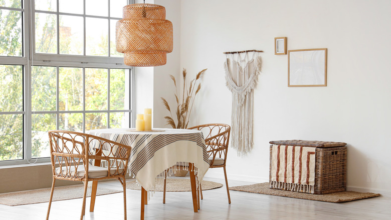 Interior of dining room with round table, candles, and large windows