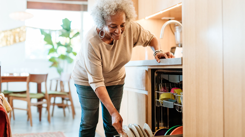 Woman loading dishwasher