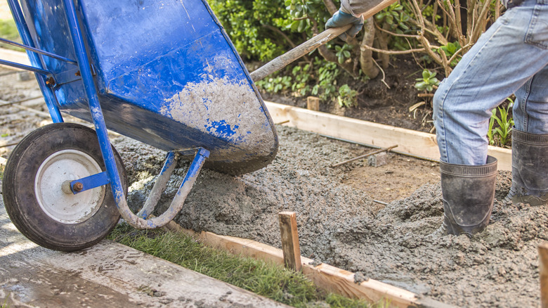 Person pouring concrete from wheelbarrow