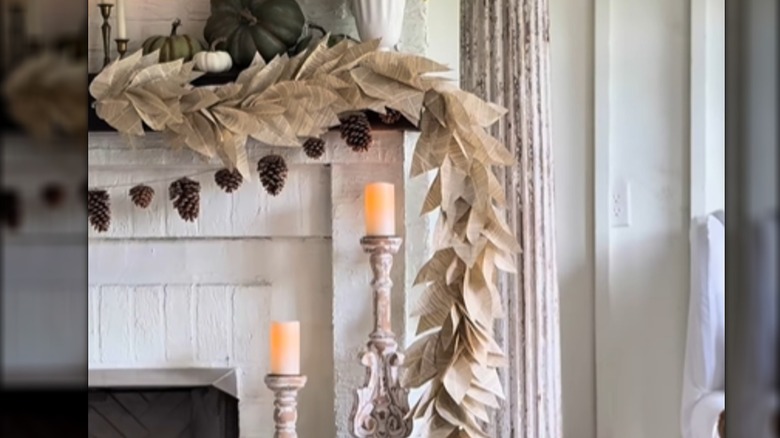 A leafy garland made from book pages decorates a fireplace mantel