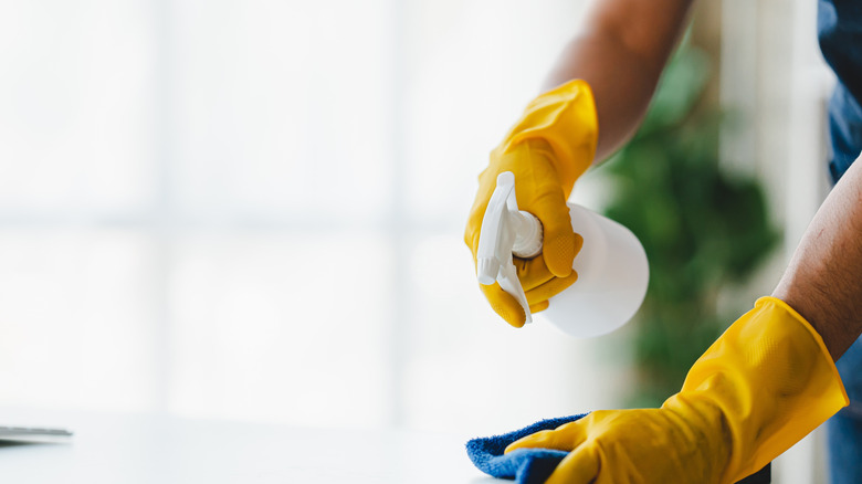A spraying glass cleaner from a white spray bottle