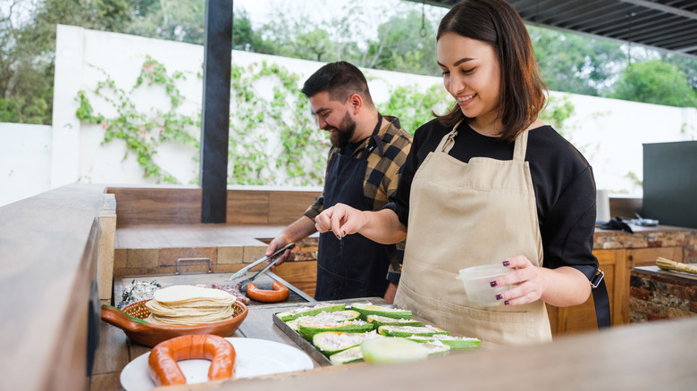 Couple using outdoor kitchen