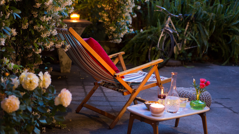 Striped lounging chair in backyard with candles and flowers