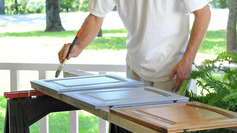 man painting kitchen cabinet