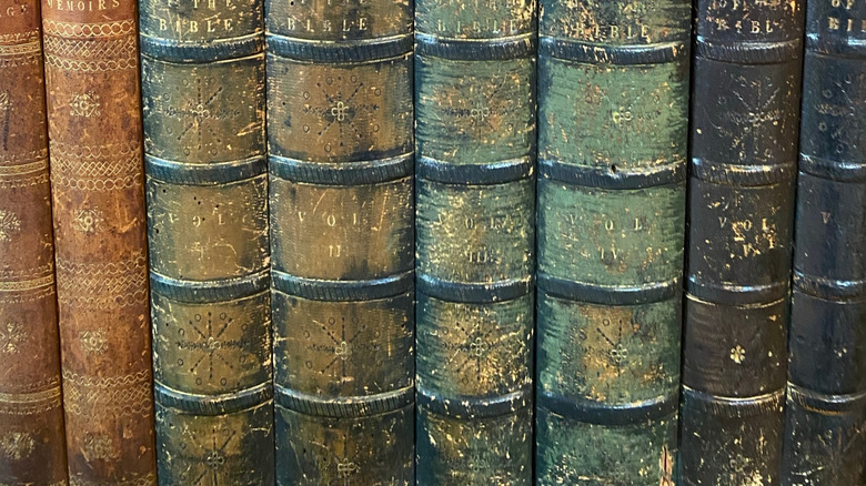 A knob and key hole in a DIY hidden library door covered in trimmed book spines.